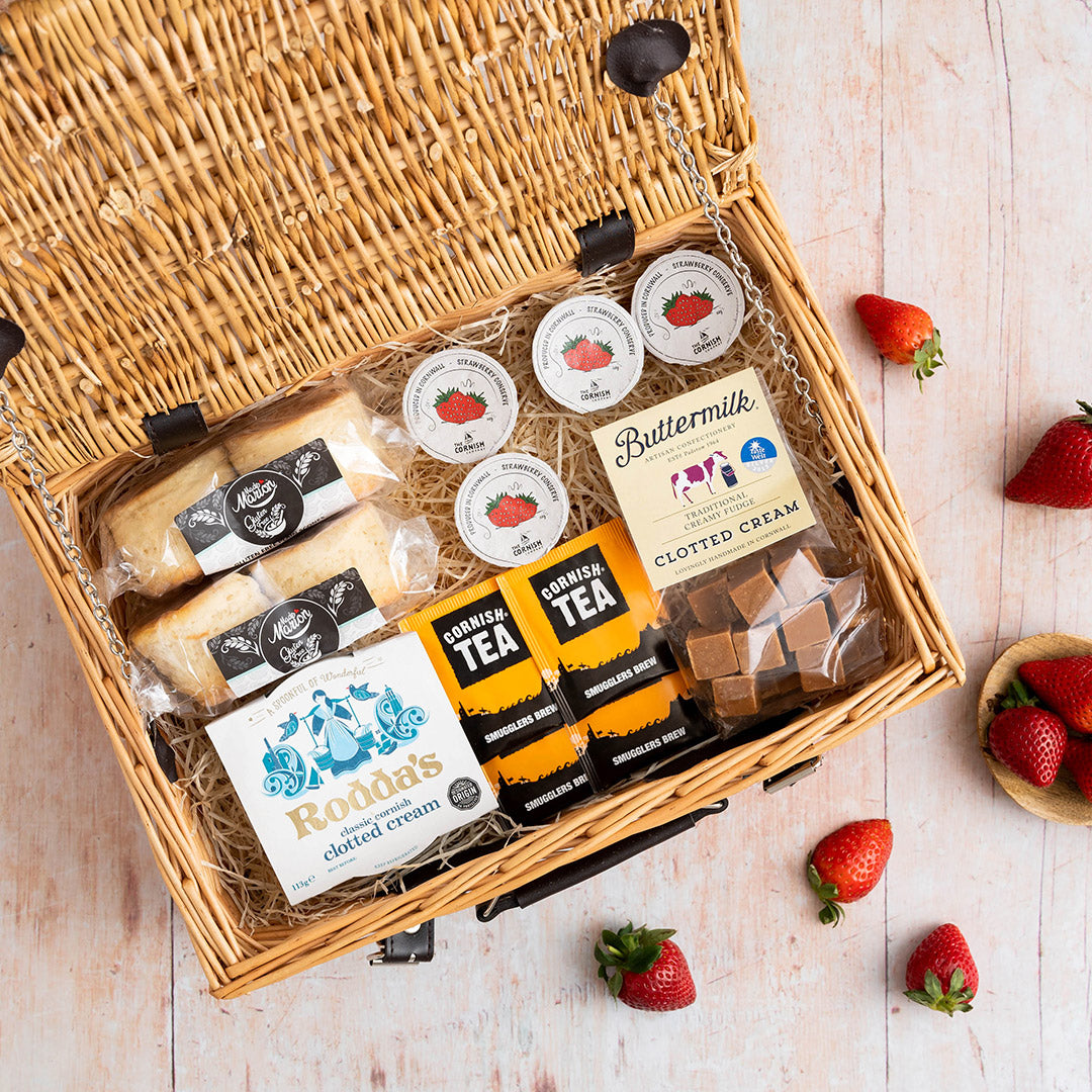 The contents of a gluten free hamper placed in a wicker basket on a wooden floor.