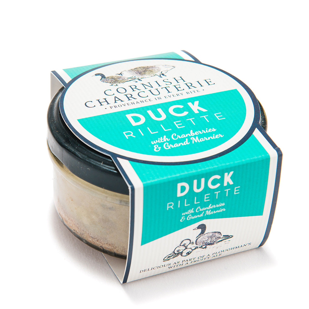 a tub of duck rillette with cranberries and grand marnier on a white background.