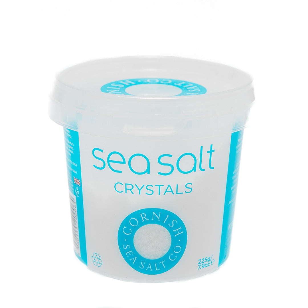 tub of cornish sea salt crystals on a white background.